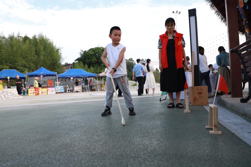 游园会中，小朋友正在体验传统游戏曲棍球